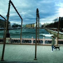 <p>A woman and her dog take in the dramatic waters while crossing the Maria Kristina zubia (bridge) in Donostia. The Urumea river flows into the Bay of Biscay just beyond those buildings, and on this winter day winds off the Atlantic were driving waves well upstream. <br /></p>