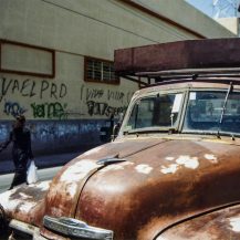 <p>A Poblana passes an old truck and graffiti promoting the centre-left PRD party.</p>