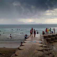 <p>Children playing along Dili's waterfront after the daily rainstorm.</p>