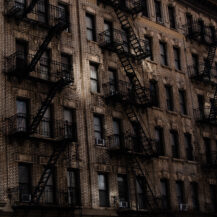 <p>Reflections bounce sunlight onto the bricks and characteristic fire escapes of some New York apartments.</p>