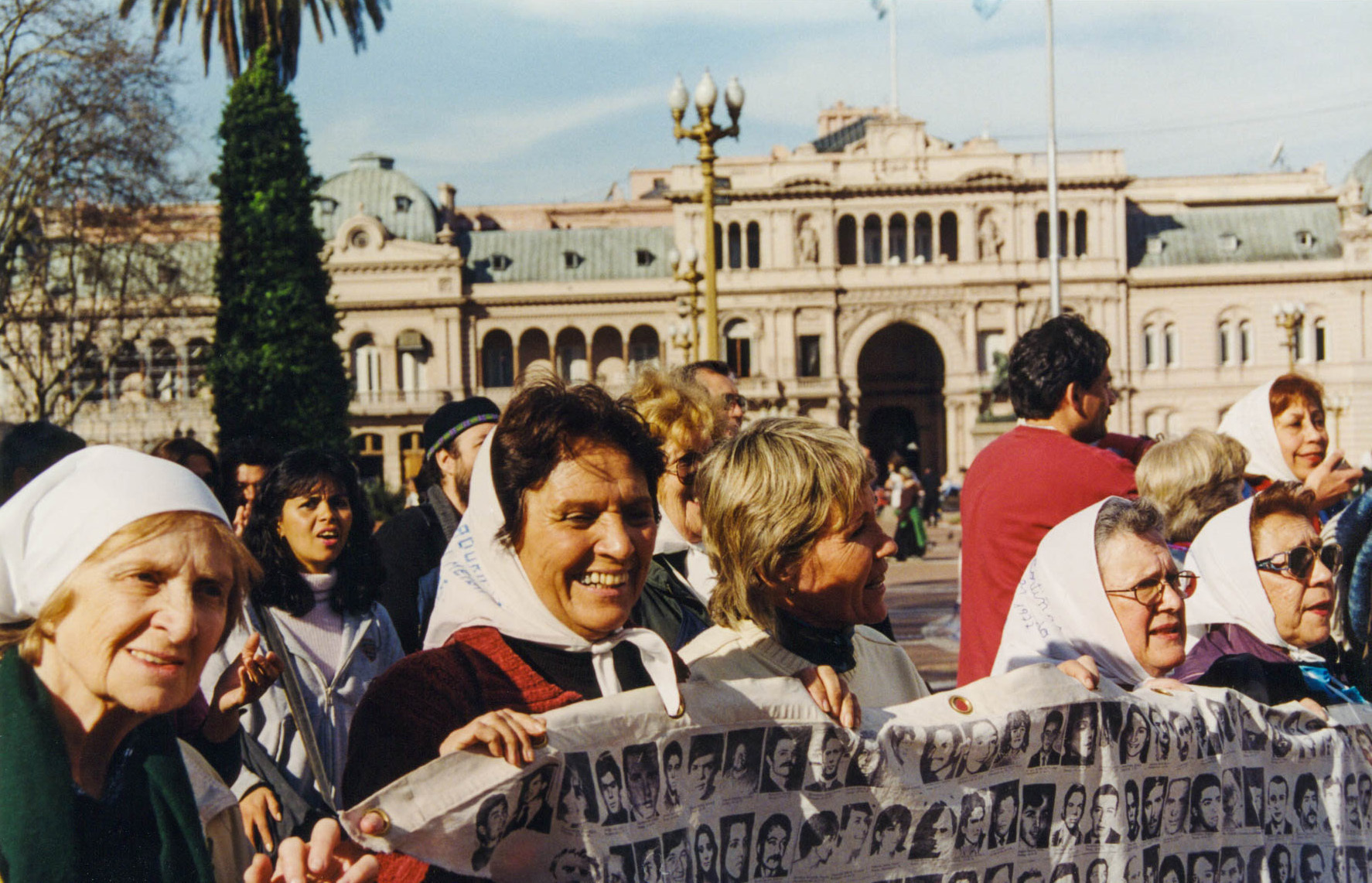 <p>Members of the Madres de la Plaza de Mayo carry a banner displaying portraits of their relatives disappeared by Argentina's military junta of 1976-1983. <br /></p>
<p>Mothers, grandmothers, and other relatives began these marches during the dictatorship, gathering each Thursday at the Plaza de Mayo to demand accountability and justice for their missing loved ones. Their movement adopted the name of the square. <br /></p>
<p>This photo was taken in 1999, 22 years after they had commenced their rallies. They continue marching to this day.</p>