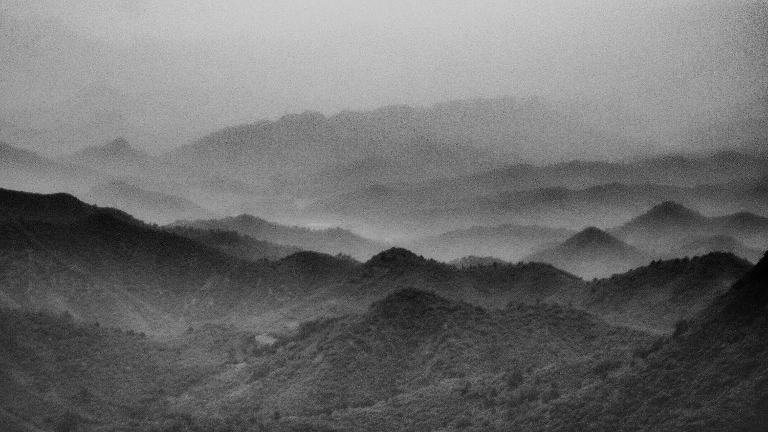 <p>A view over misty hills, seen from a stretch of the Great Wall.</p>