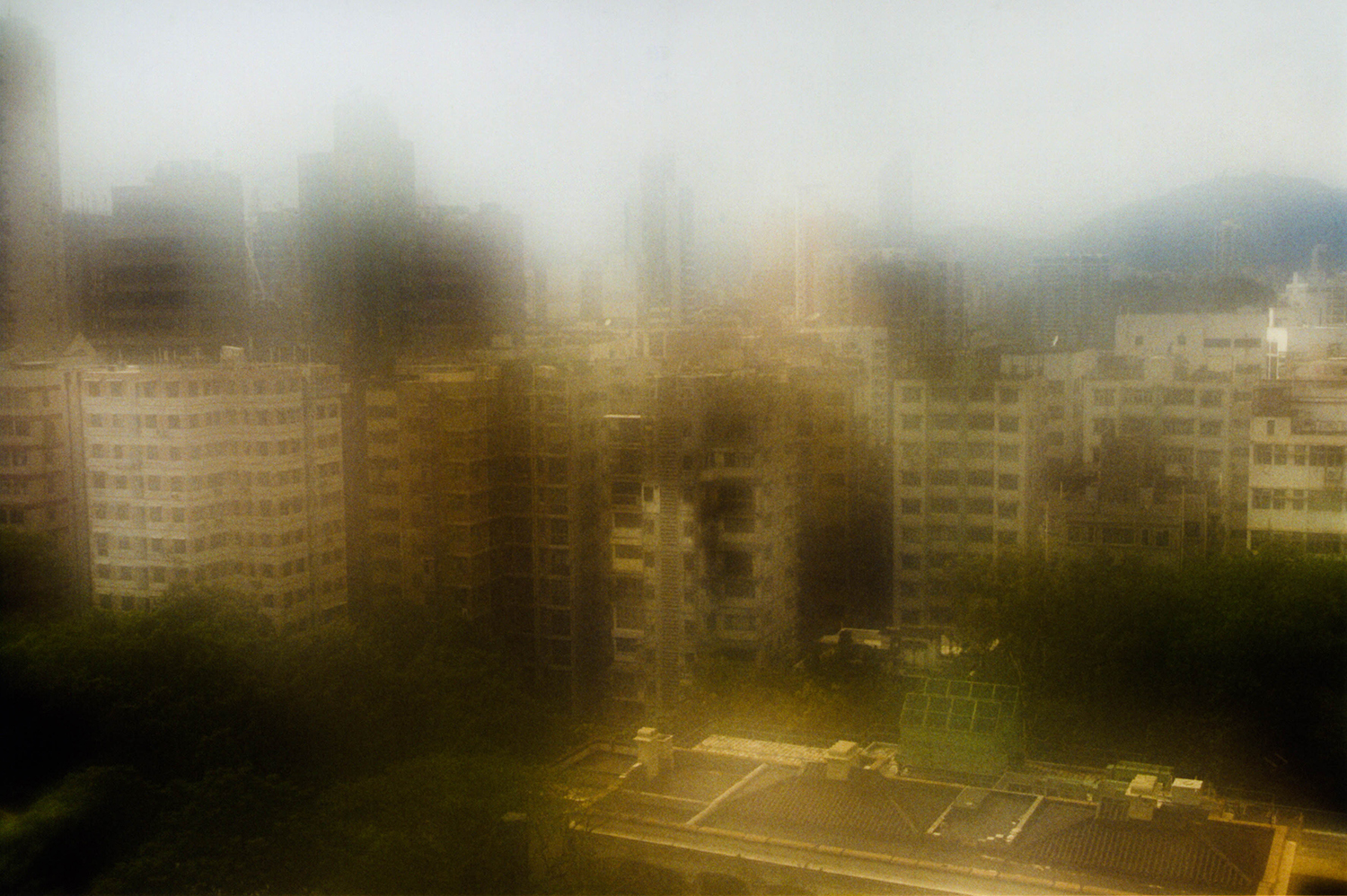 <p>A view over the rooftops of Kowloon, near the Hong Kong Observatory. The blur results from condensation on the lens due to a rapid transition from a climate-controlled interior to Hong Kong's humid exterior.</p>