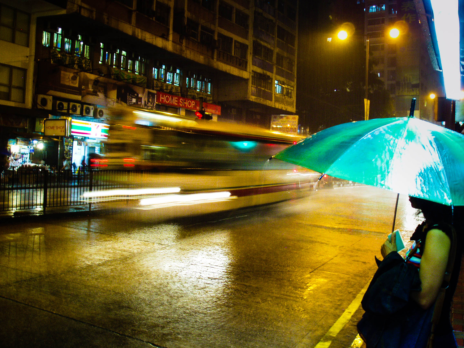 <p>A woman shields herself from one of Hong Kong's sudden, torrential rain storms.</p>