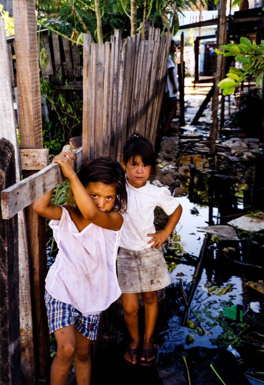<p>Two girls explore their flood-damaged former neighbourhood just behind the national congress on the banks of the Paraguay River. Their homes were flooded a few weeks before Christmas in 1997, forcing their already struggling families to relocate to makeshift residences in a public square.</p>