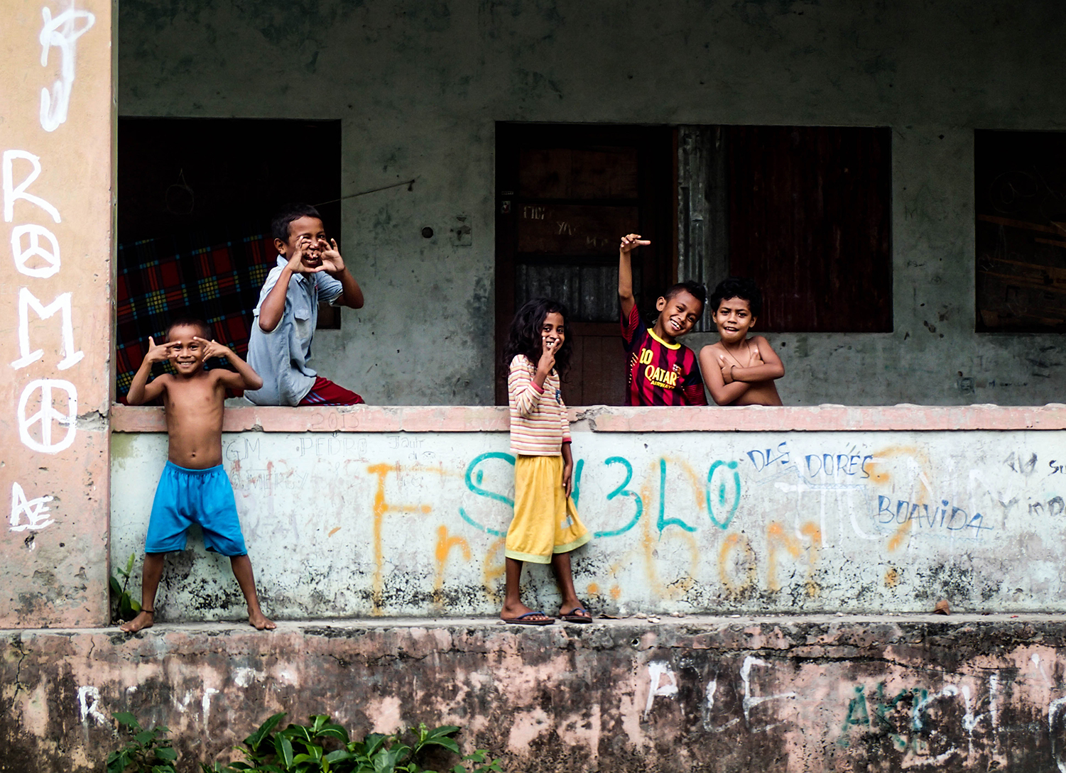 <p>A group of kids very amused to have their picture taken. <br /></p><p>Part of the graffiti reads 'Das dores boavida', which can translate as 'From pain, a good life'.<br /></p>