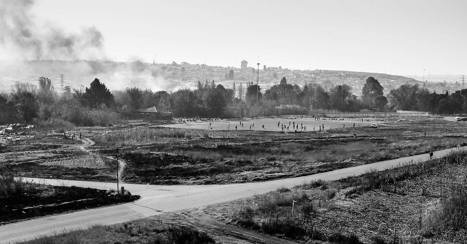 <p>Smoke and soccer in Soweto.</p>